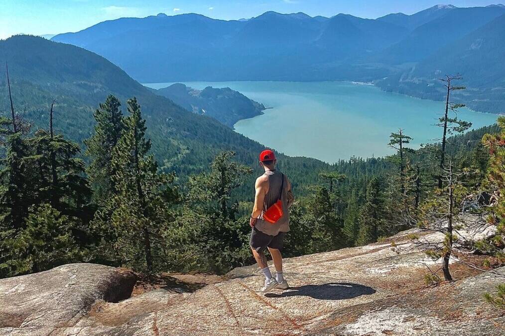 A person looking out towards a river from a mountain