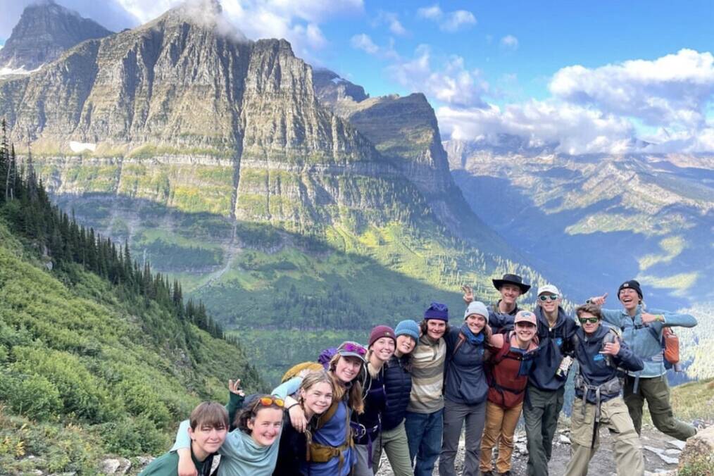 A group of people posing in front of a mountain in the US