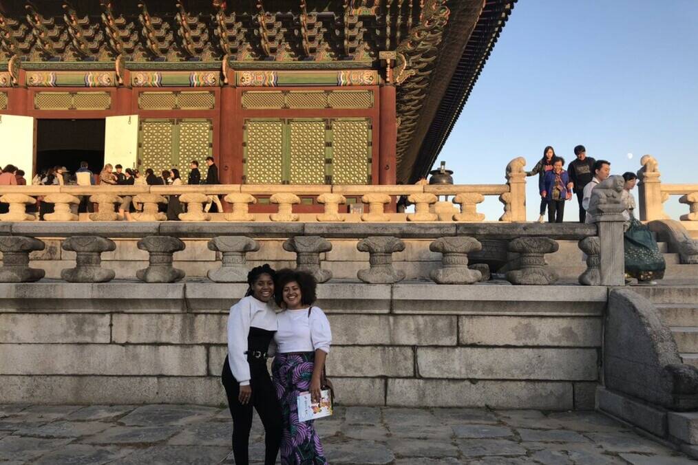 Two people standing in front of a Korean temple