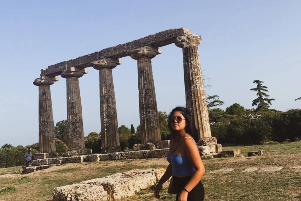 A person standing next to ancient structures in Metaponto, Italy
