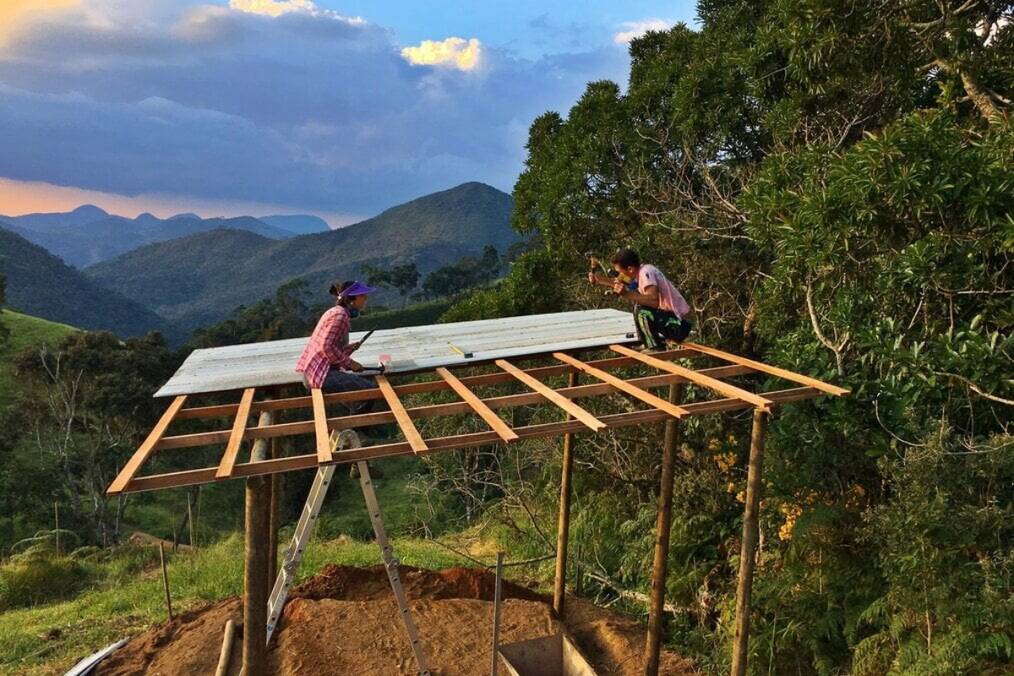 Two people working on a construction project with a scenic backdrop