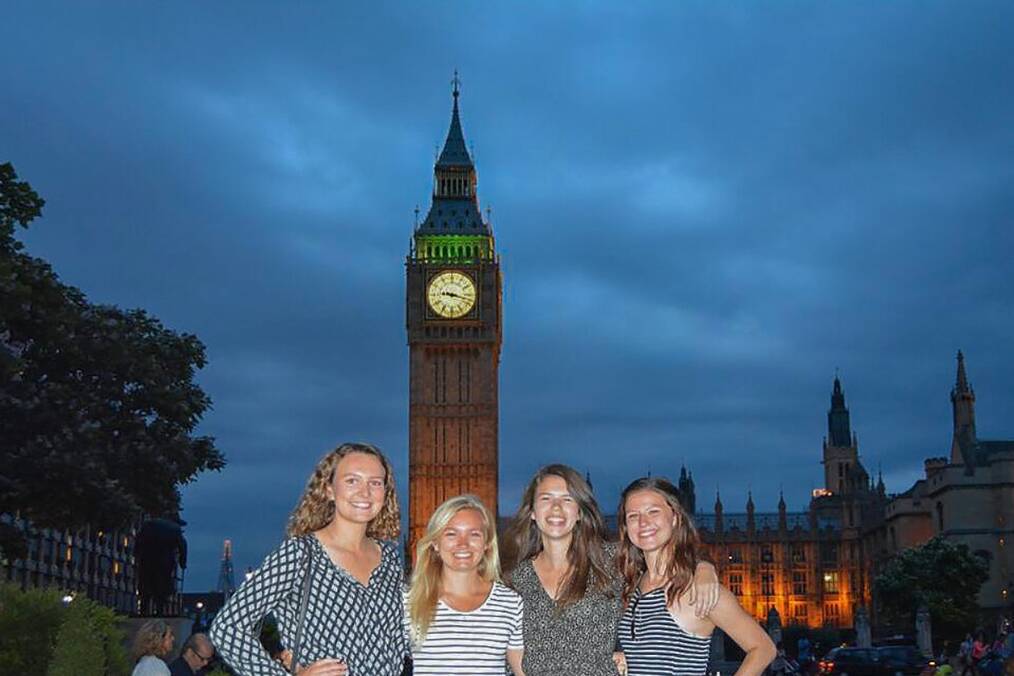 Four friends posing in front of Big Ben, London