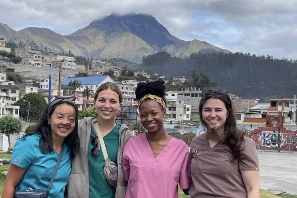 A group of medical workers posing in front of a mountain