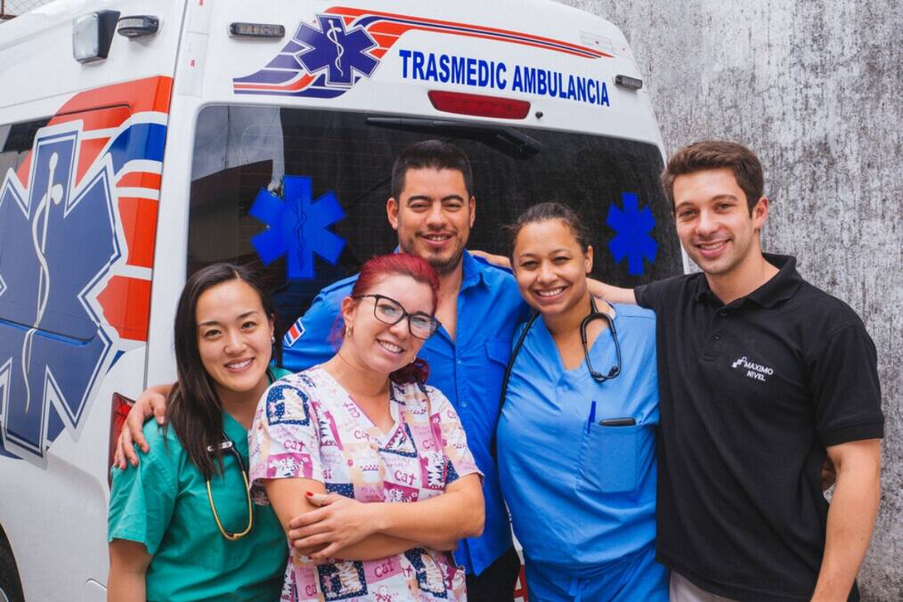 A group of medical workers standing in front of the ambulance 