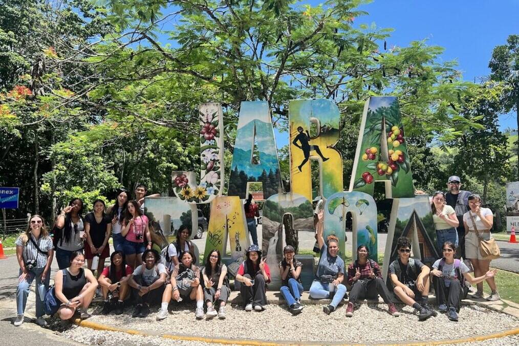 A group of students sitting near a large sign