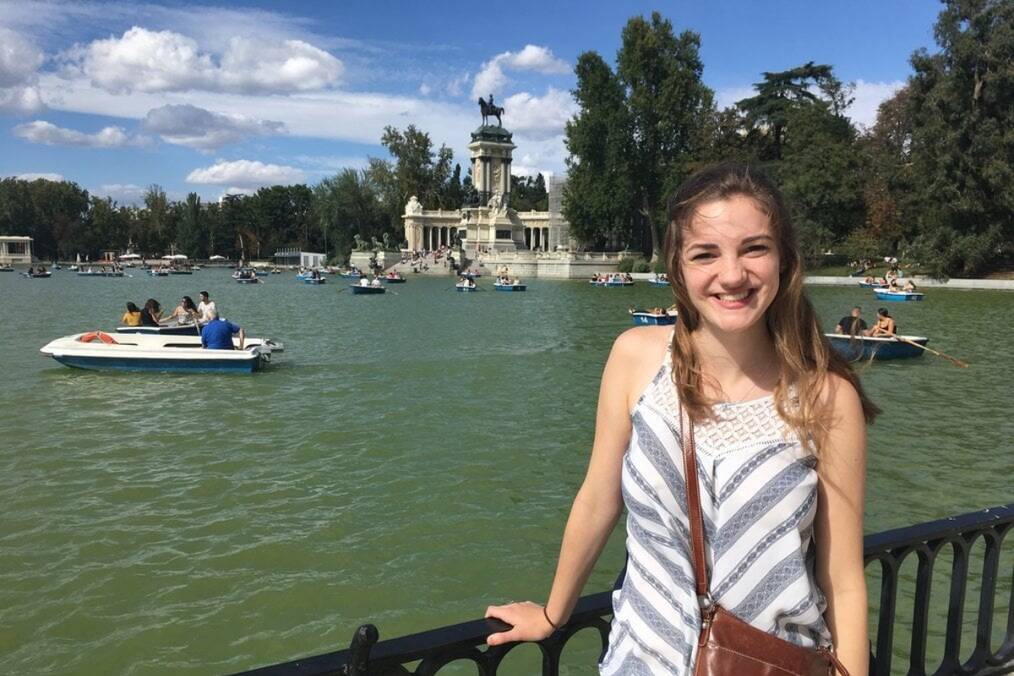 A person smiling next to a lake in Spain