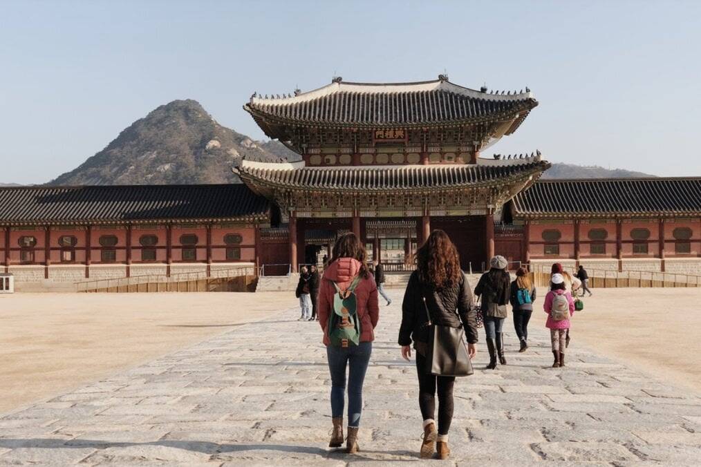 People walking towards a Korean Palace in Seoul