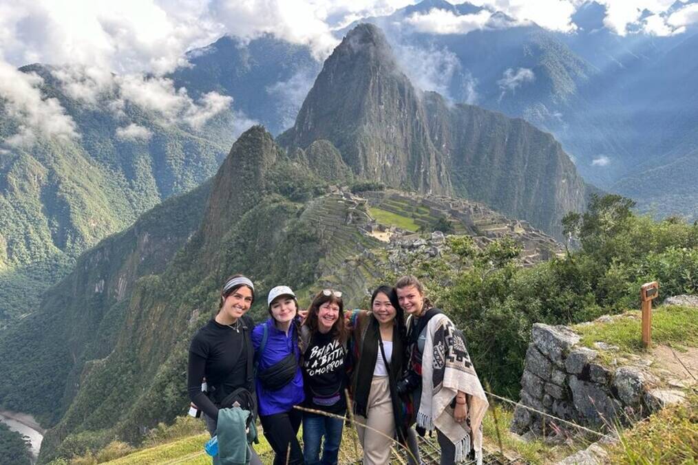 A group of people posing in front of Machu Picchu