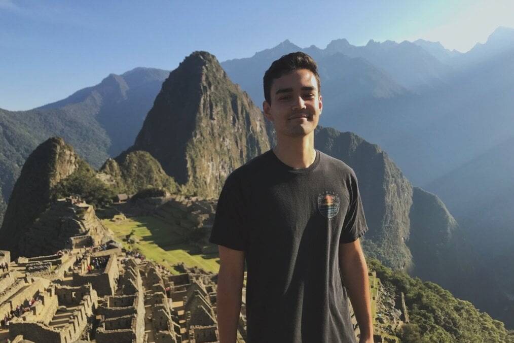 A person standing and posing in front of Machu Picchu, Peru