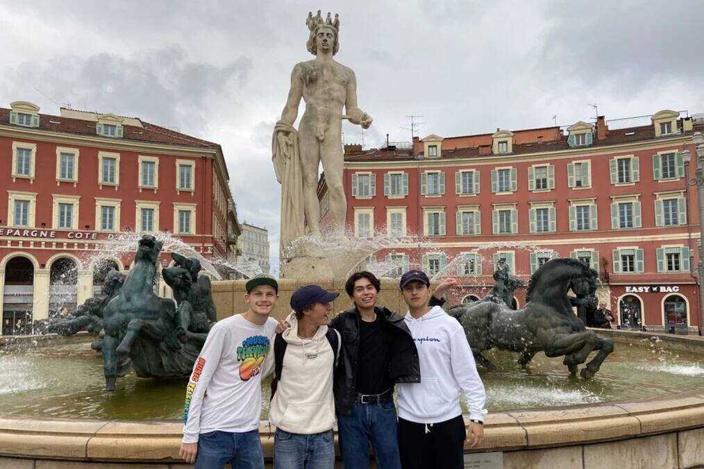 A group of students standing in front of a statue