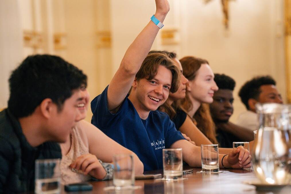 A person smiling and raising their hands