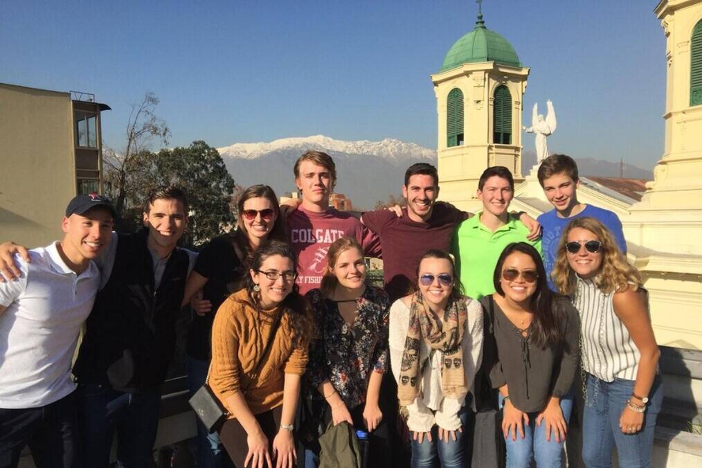 A group of interns smiling in front of a scenic backdrop