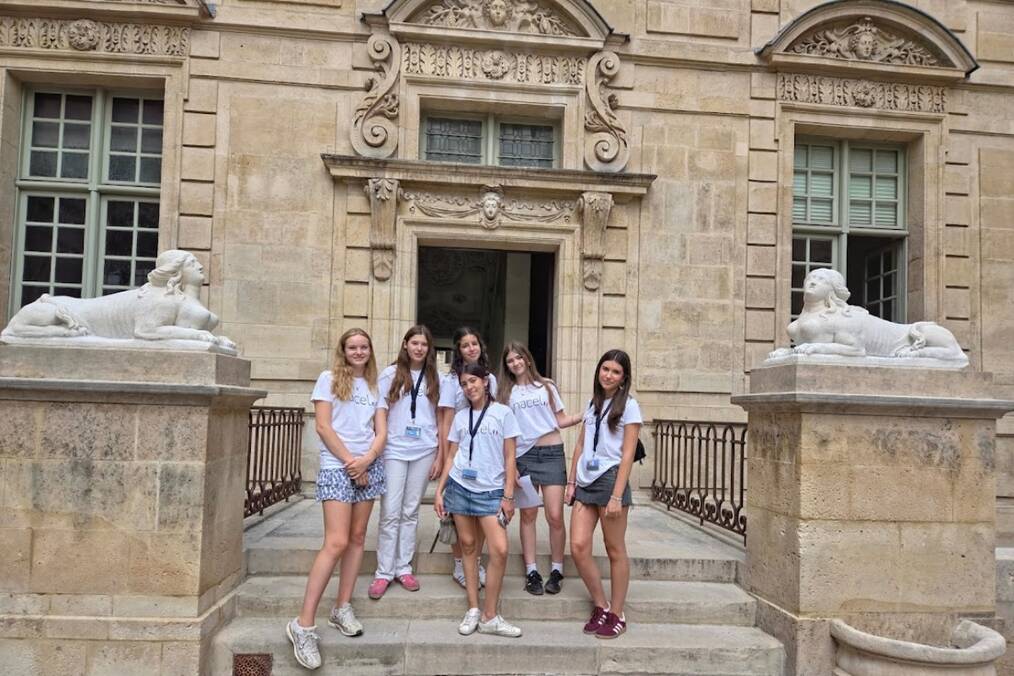 A group of friends standing on a step of a French building