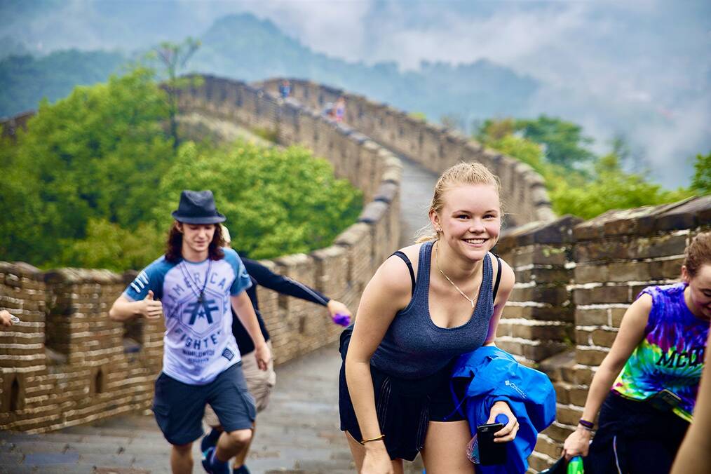 Students smiling while hiking the Great Wall of China