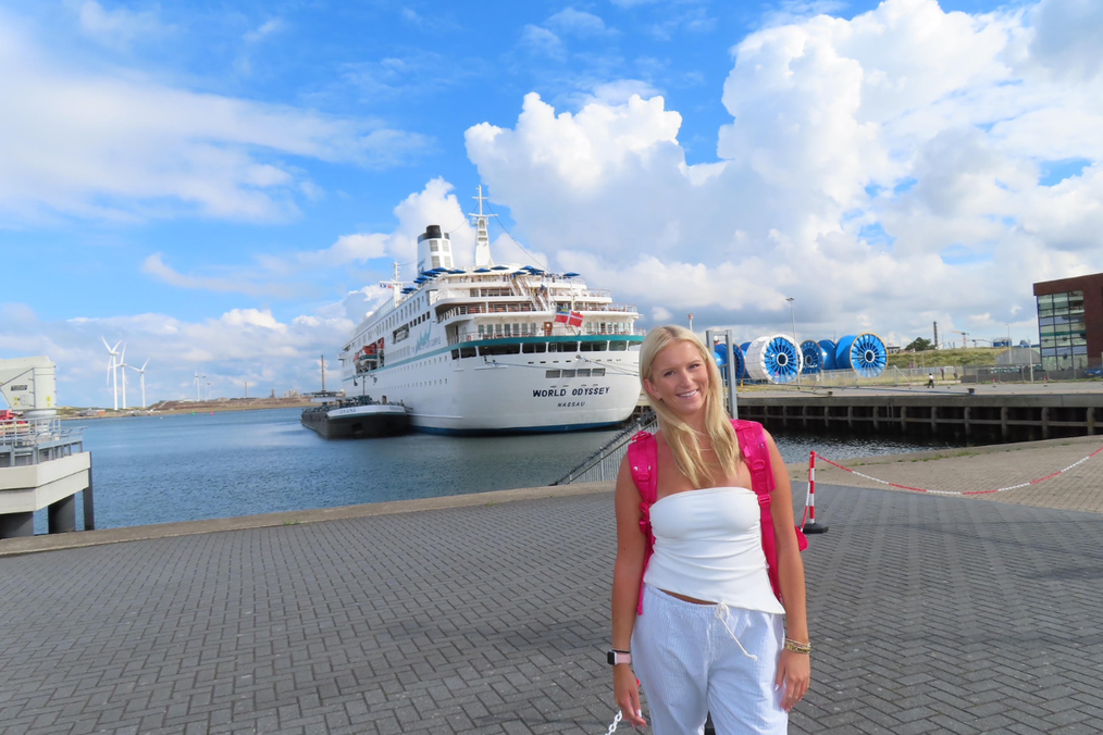 Semester at Sea student smiling in front of the docked ship