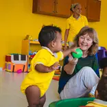 Toddler and senior volunteer playing with a ball