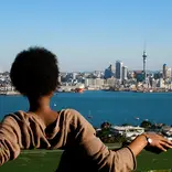 A student visiting Mount Victoria in Devonport, Auckland, looking at Auckland CBD's skyline
