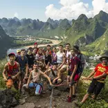A group photos of students backdropped by Yangshuo landscape