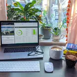 A desk with a laptop, glasses, and coffee - all ready for a day at your virtual internship!