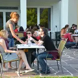 Participants sitting around tables on the terrace and talking