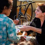Volunteer helping with breakfast programme at community project in Cambodia