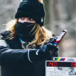 the 2nd AC holds up a slate at the start of a take