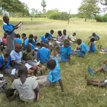A girl child leading the rest of the children to read and concentrate on what took them to school.