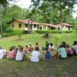 Students sitting in a circle on the grass at a field research station