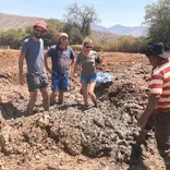 3 students preparing the mud to make adobe bricks