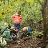 An instructor shows students how to find identify wild edibles. 