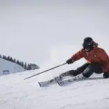 Woman skiing down a groomed piste
