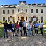 Group of diverse male and female students standing in front of university building