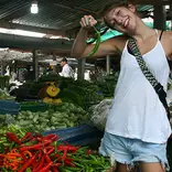 a teacher poses with a chili in a thailand market