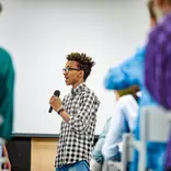 A student speaking through a microphone