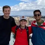 Students posing on overlook above city of Rome