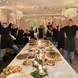 Kitchen team standing around table full of food