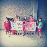 Alisha and her friend colour in daycare center