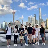 Students posing with Shanghai skyline behind them 
