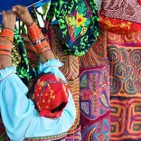 Panamanian woman hanging colorful textiles on a clothes line