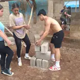 Construction volunteers arrainging bricks