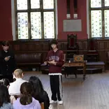 Three students presenting in the Oxford Union