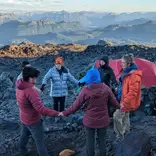 Crew circles up on a rocky summit