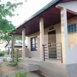 A white stucco porch facing a tamarind tree