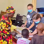 Volunteers and local staff documenting patient information inside the Maisha clinic during a medical care day