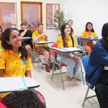 A group of international students sitting in a vibrant classroom during an orientation session in Sukhothai, Thailand.