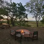 Camp fire and chairs in the bush