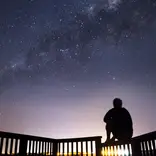 Student poses beneath star filled sky.