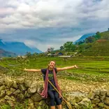 Student standing in front of rice fields