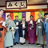 Group of students in kimonos in front of a colorful wall
