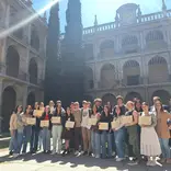 Students with certificates at historic university campus 